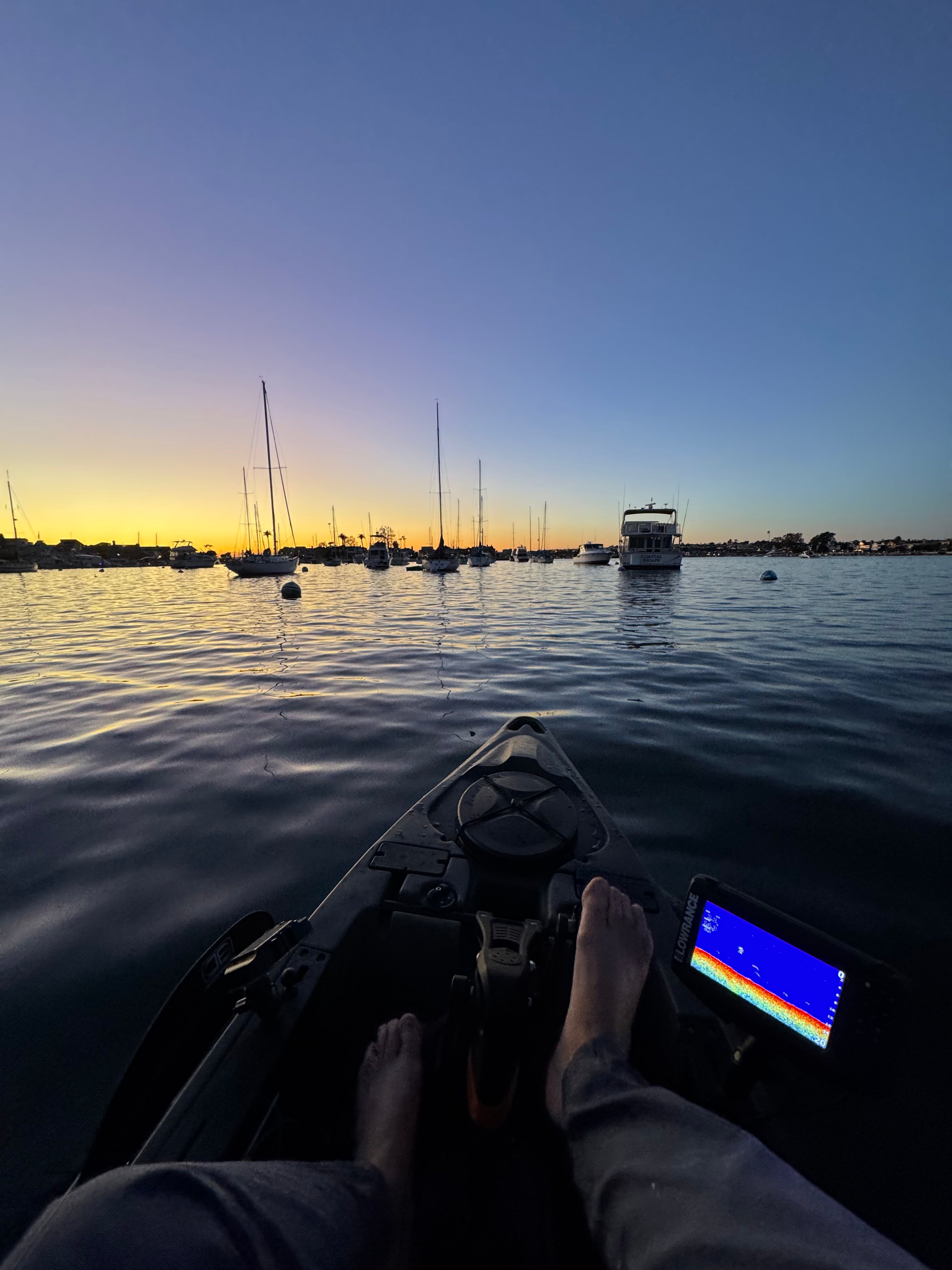 Bow of a kayak with a sunrise in the background